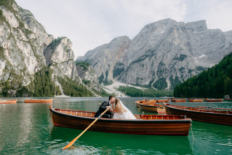 A kiss in a wooden rowing boat on Lago di Braies, the final stop of a Dolomites elopement, Emma-Jane Photography