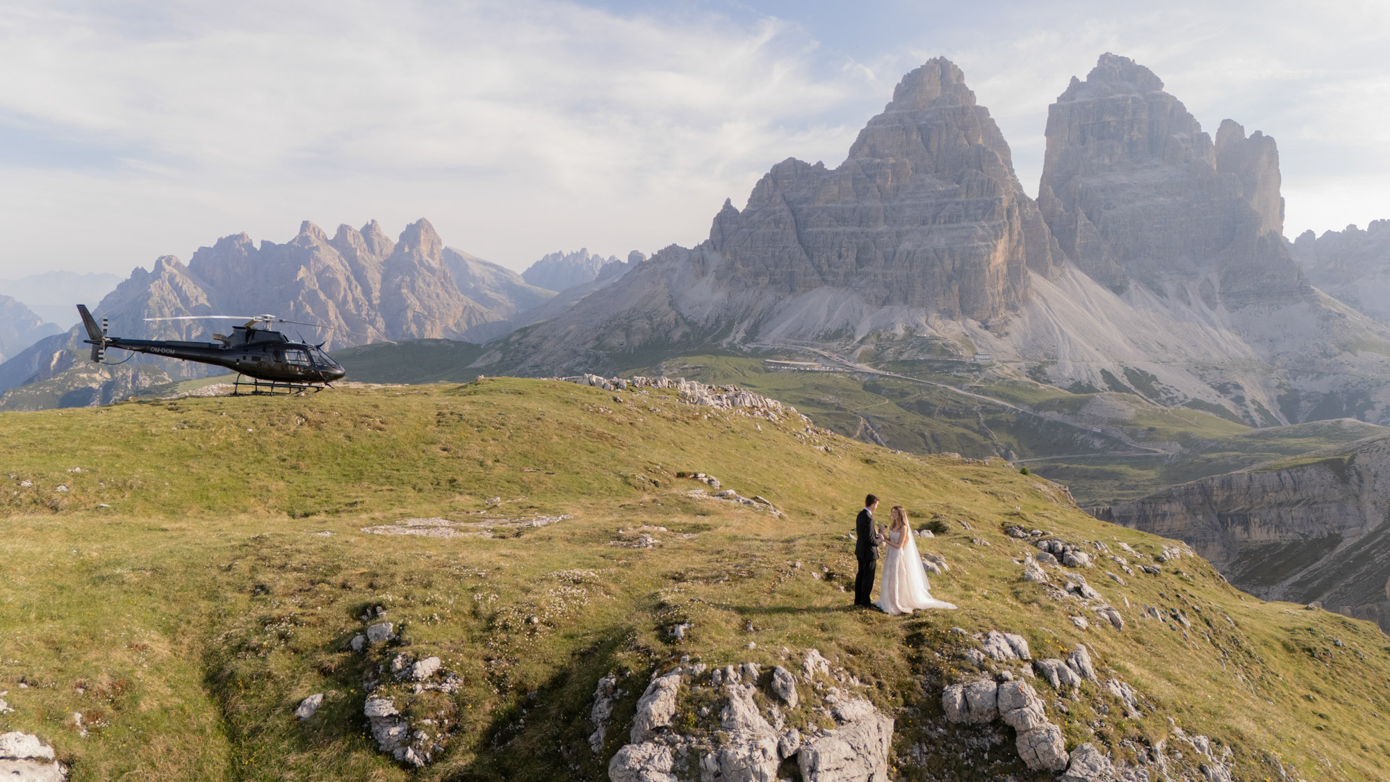 A helicopter elopement in the Dolomites, the couple on an alpine meadow below the Tre Cime di Lavaredo, Emma-Jane Photography