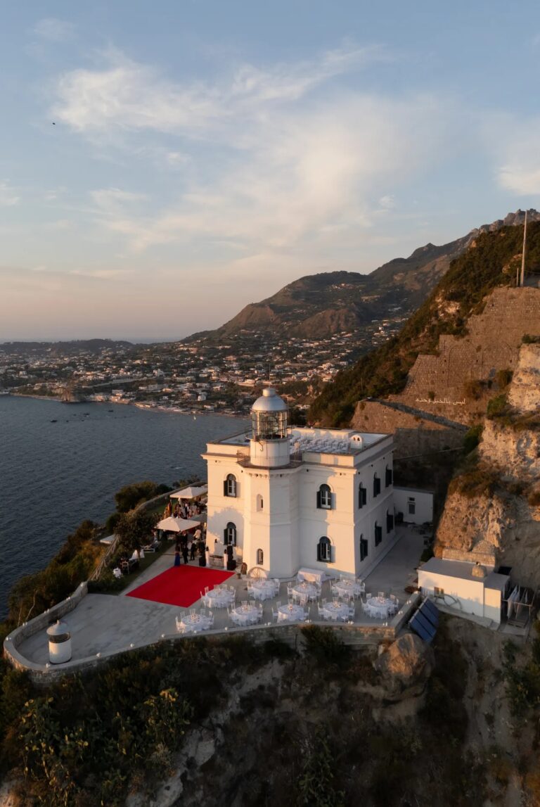 From above: a lighthouse on the cliff, tables set on its terrace, Ester Chianelli Weddings & Events