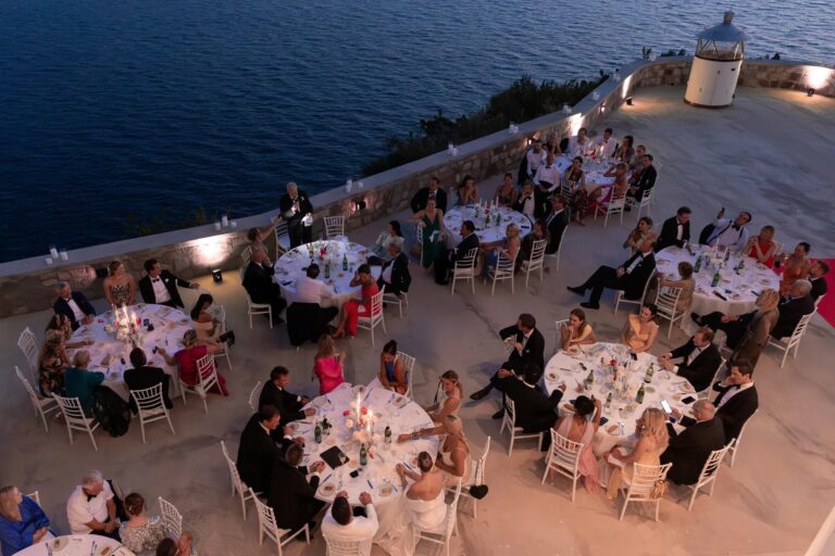 The terrace at night, round tables and the sea beyond the parapet, Ester Chianelli Weddings & Events