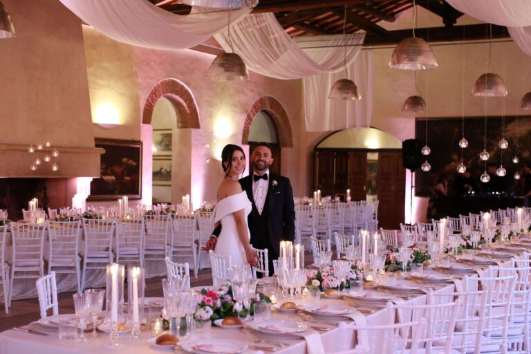 Long tables in the hall of the Antiche Scuderie Odescalchi, pink linen, candles and draped ceiling, Eventilab Weddings