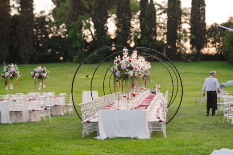 A long table on the lawn at Villa Dino under a circular floral frame at sunset, Eventilab Weddings