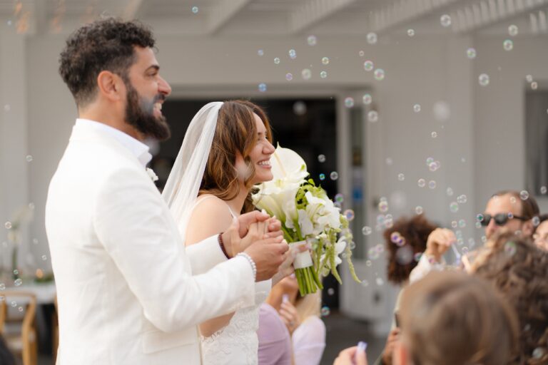 A couple greeted with bubbles after their ceremony on a white terrace, Eventuries Wedding Planning and Styling