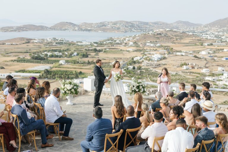 A hillside ceremony with guests seated in rows facing the couple and the Paros landscape, Eventuries Wedding Planning and Styling