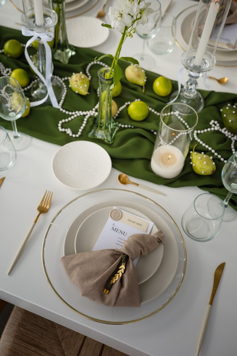 A table laid with a green runner, limes, candles and white flowers, Eventuries Wedding Planning and Styling