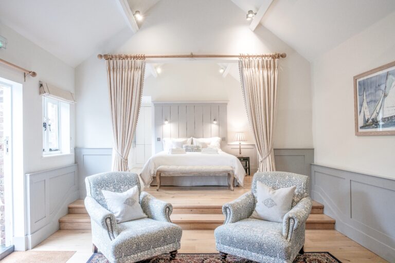 The couple's suite, with two upholstered armchairs below a raised sleeping area, Farbridge