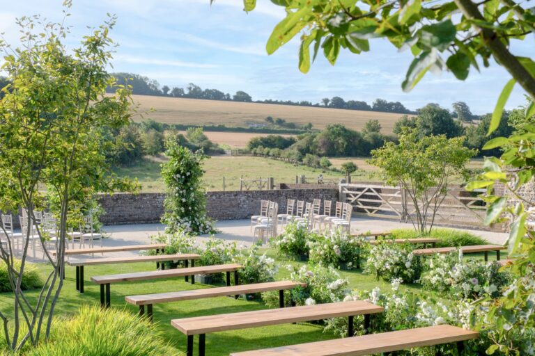 Outdoor ceremony benches on the lawn with views over the Lavant valley and the South Downs, Farbridge