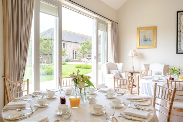 The Breakfast Room laid for the morning after, with glazed doors looking out to the barns, Farbridge