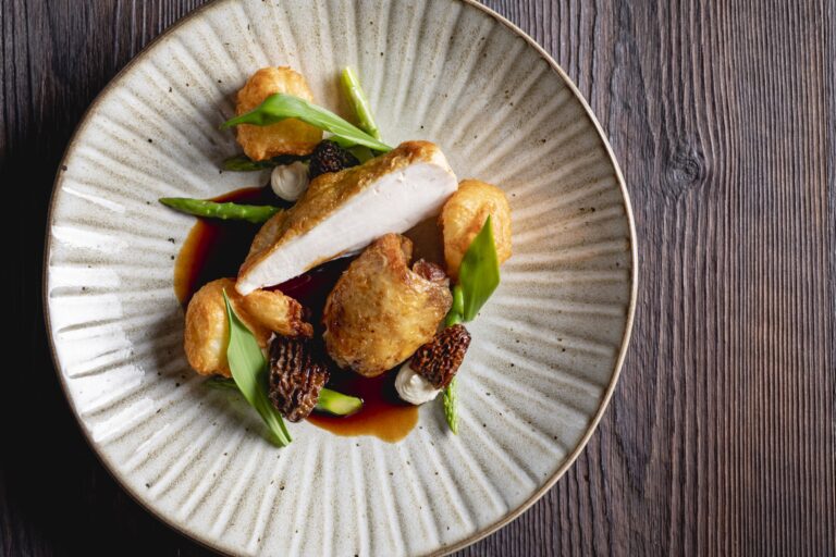 Roast chicken with morels and wild garlic leaves on a stoneware plate, Farbridge