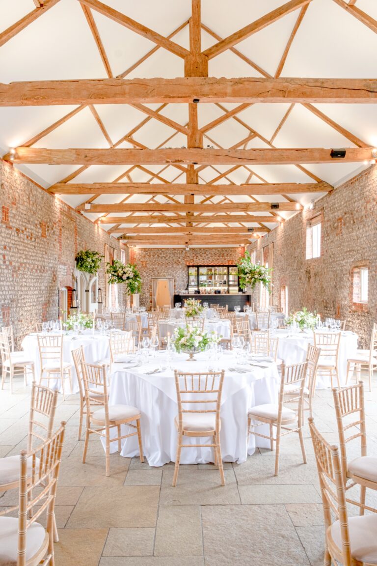 The full length of the Lavant Valley Barn, laid with round tables on a flagstone floor, Farbridge