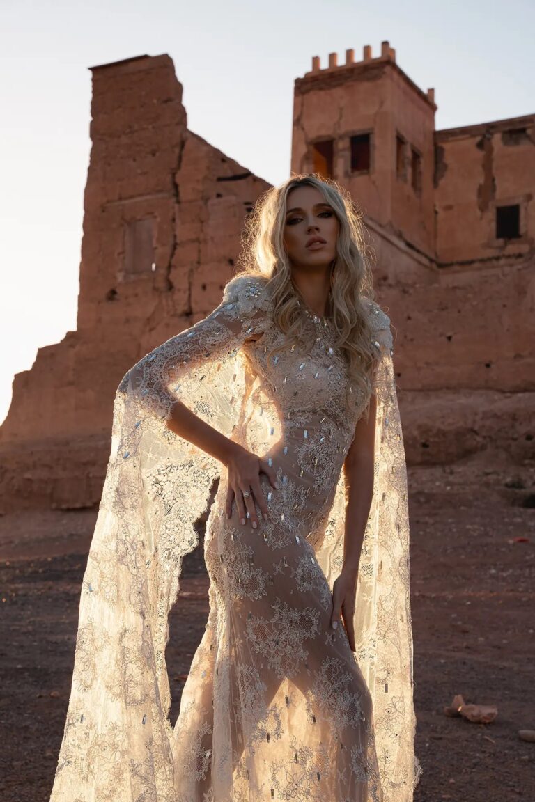 Ferdinand Atelier couture: a beaded gown with draped sleeves before a red kasbah
