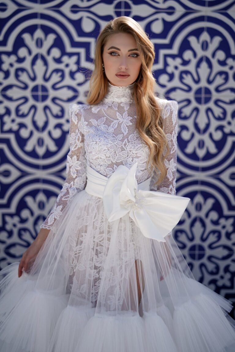 Ferdinand Atelier couture: a lace gown with a satin bow before blue tiles