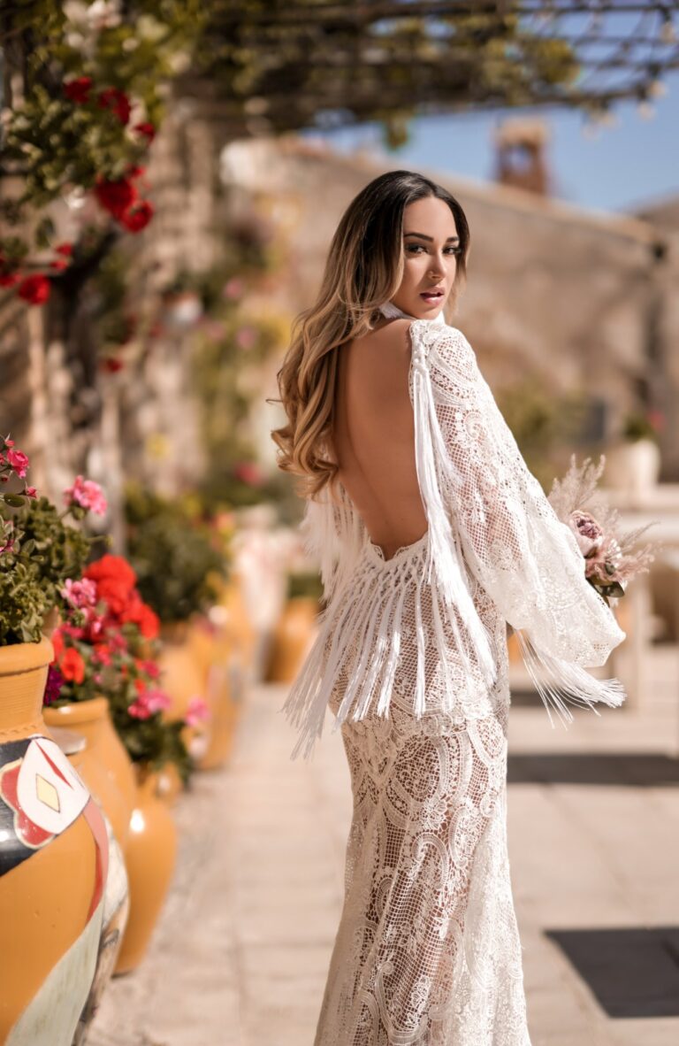 Ferdinand Atelier couture: an open-back lace gown on a flower-lined street