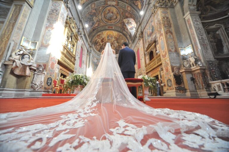 Bride at the altar of a baroque church beneath a long lace veil, Fiori Amore Fantasia