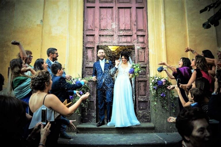 Couple leaving a church as guests throw confetti, Fiori Amore Fantasia