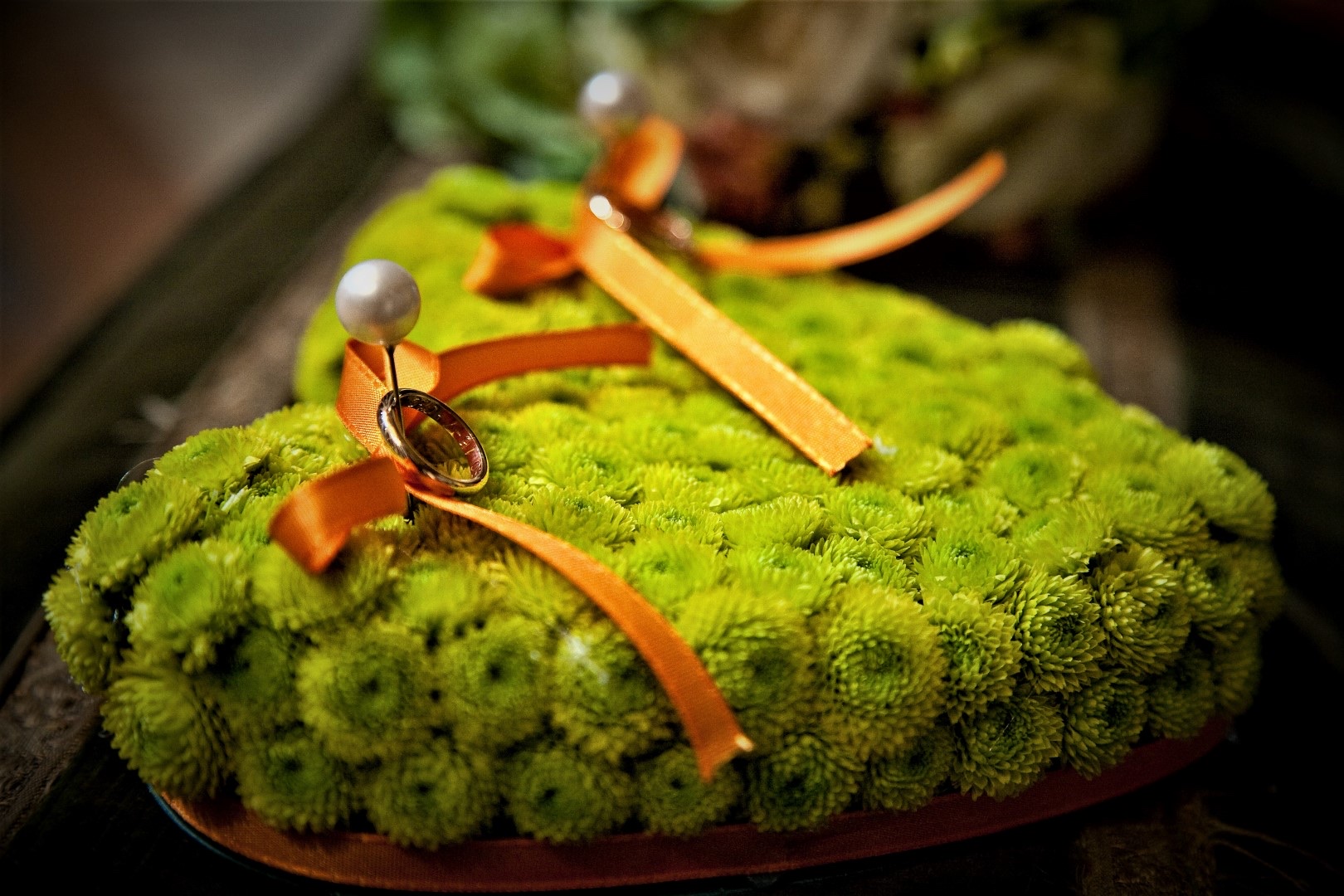 Ring cushion made from a heart of green blooms, tied with orange ribbon, Fiori Amore Fantasia