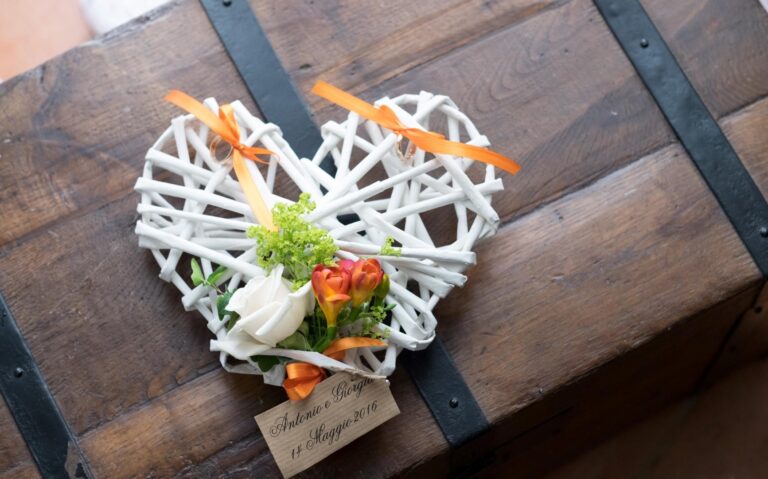 White willow heart holding orange and green blooms on a wooden chest, Fiori Amore Fantasia