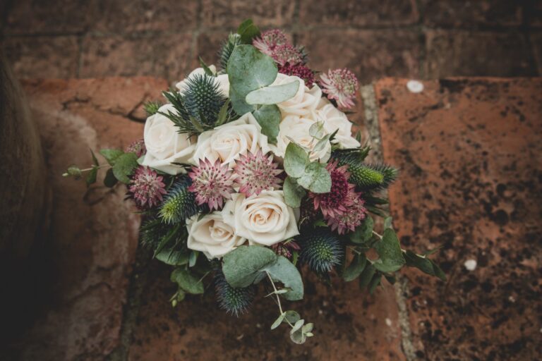 Bouquet of white roses, thistle and eucalyptus on terracotta paving, Fiori Amore Fantasia