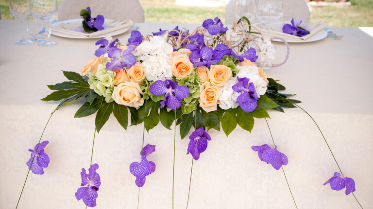 Head table runner of peach roses and purple orchids trailing down the cloth, Fiori Amore Fantasia