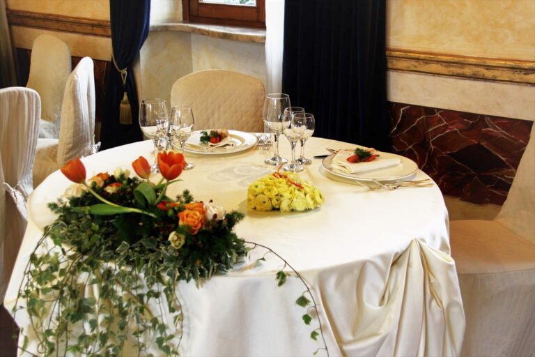 Round table with a trailing centrepiece of orange and yellow flowers and ivy, Fiori Amore Fantasia