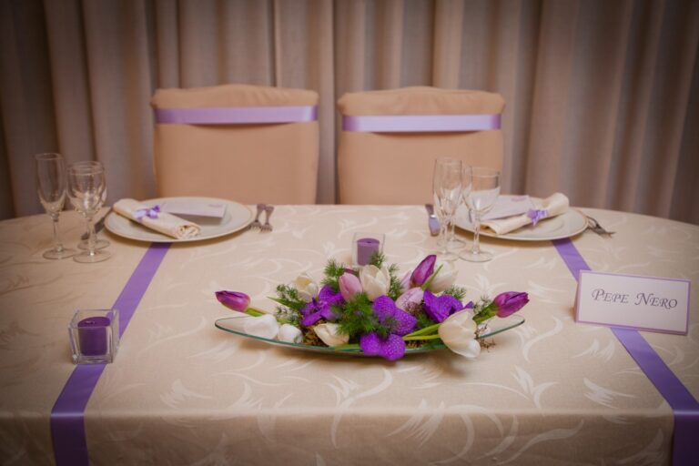 Low table arrangement in purple and white with matching ribbon on the chairs, Fiori Amore Fantasia