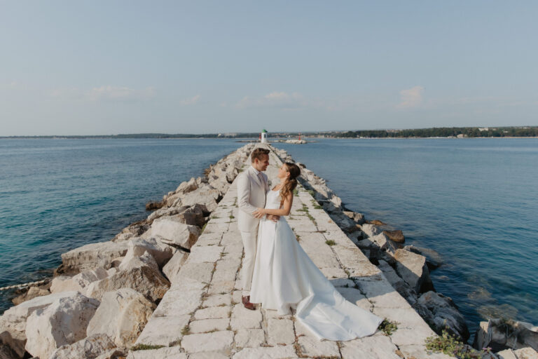 A couple at the end of a long stone jetty stretching into the Adriatic, Flammeum