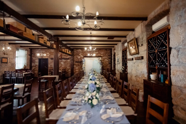 A long table dressed in blue and white flowers in a stone-walled dining room, Istria, Flammeum