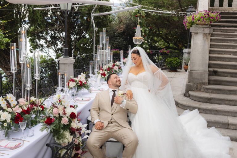 Glass candelabra and red and white florals on the couple's table beside stone steps, Istria, Flammeum