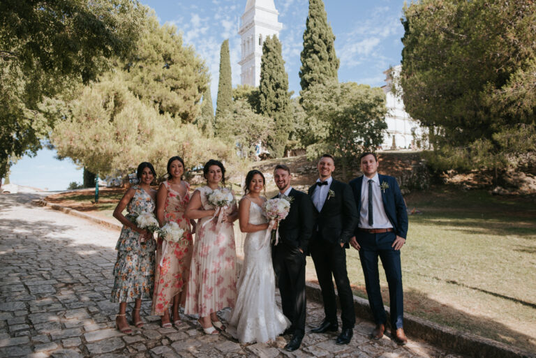 The wedding party on a paved path under pine trees by the sea, Rovinj, Flammeum