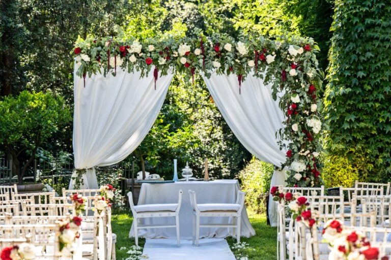 A ceremony arch of white drapes and red garden roses, Castello di Tor Crescenza, Flavia Bruni