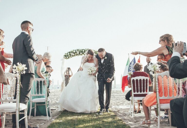The couple walk through confetti after a beach ceremony, Castello Miramare, Flavia Bruni