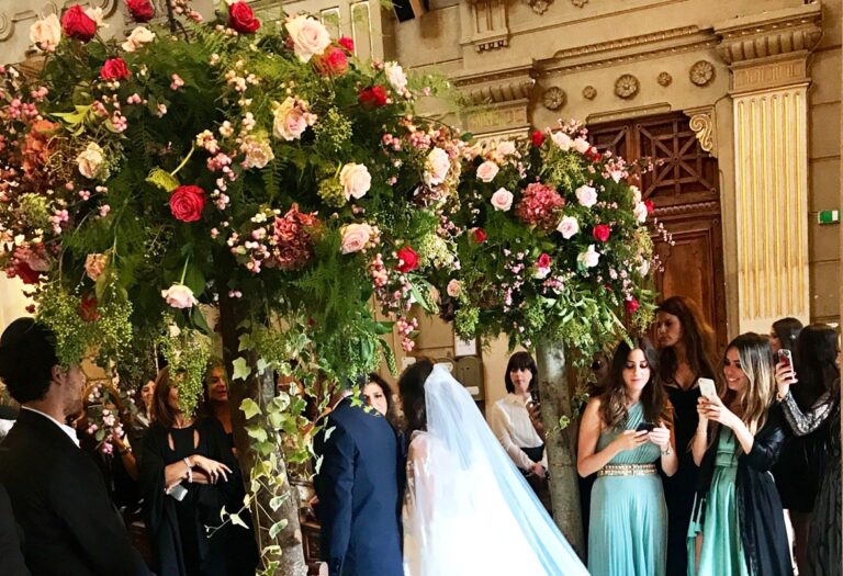 Guests gather beneath a floral chuppah of garden roses and greenery, Flavia Bruni