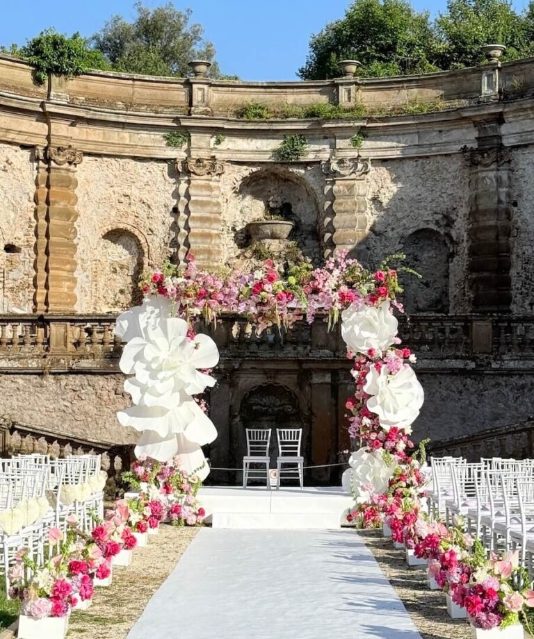 A floral chuppah rises against the ruins of Villa Mondragone, Floreventi
