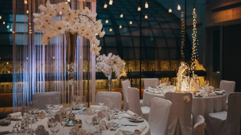 Reception tables dressed with white orchids beside a glass wall, Four Seasons Hotel Gresham Palace