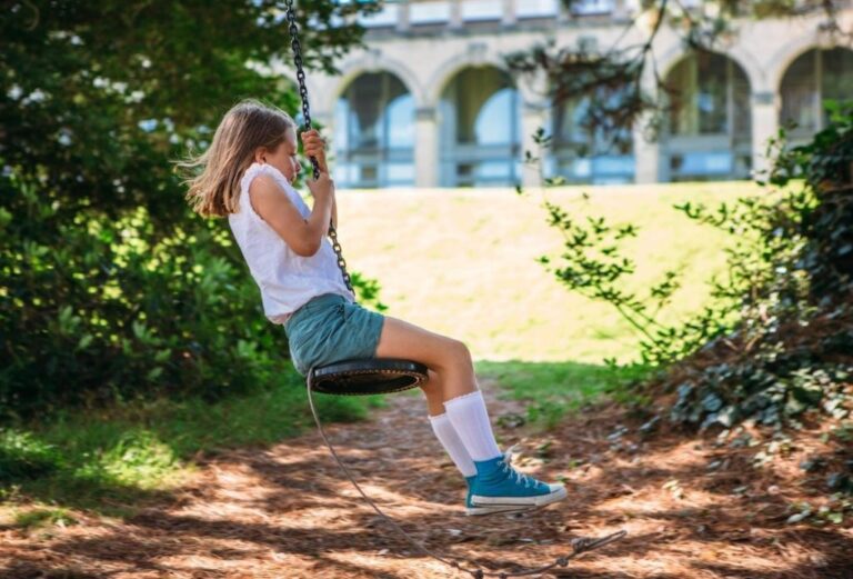 A child on a rope swing in the wooded grounds of the hotel, Fowey Hall