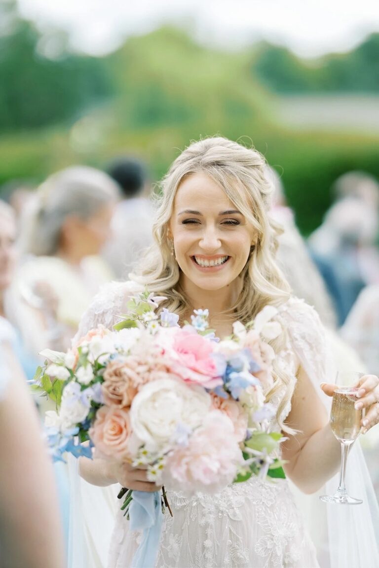 A bride, mid-laugh, with a peach and blush bouquet, Foxgloves and Roses