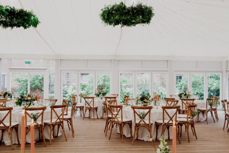 The Chaplain's Marquee laid with colour, seasonal florals rising from the tables, Fulham Palace