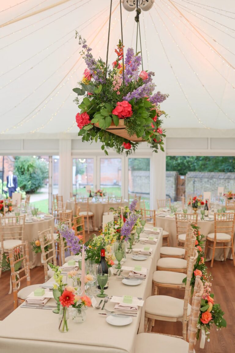 A suspended floral display over dressed tables in the Chaplain's Marquee, Fulham Palace