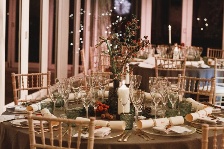 A close view of a marquee table decoration, candles and autumnal foliage along the runner, Fulham Palace
