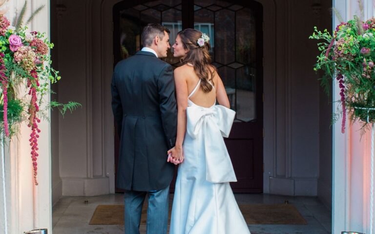 A newly married couple in a quiet moment indoors, the bride in an off-shoulder gown, Fulham Palace