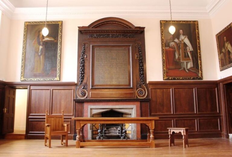 The Great Hall, panelled and hung with portraits, a fireplace at its heart, Fulham Palace