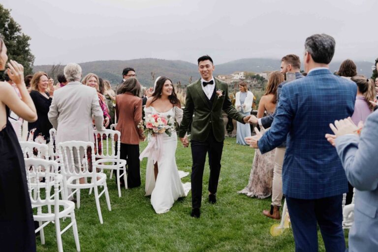 A couple leaving their outdoor ceremony at Tenuta di Artimino, Tuscany, guests applauding, Gaetano Di Giacomo Media Production
