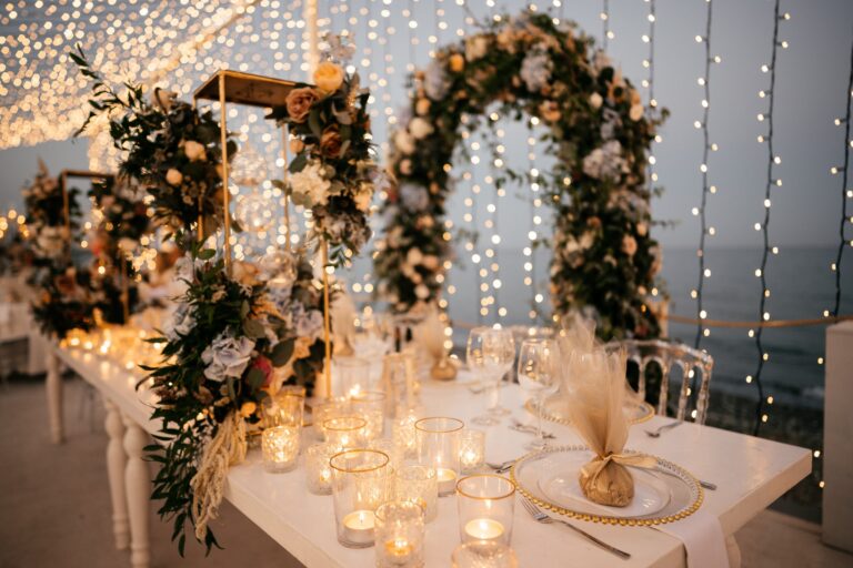 Floral arches and candles at the sweetheart table against a curtain of lights, Galu Seaside