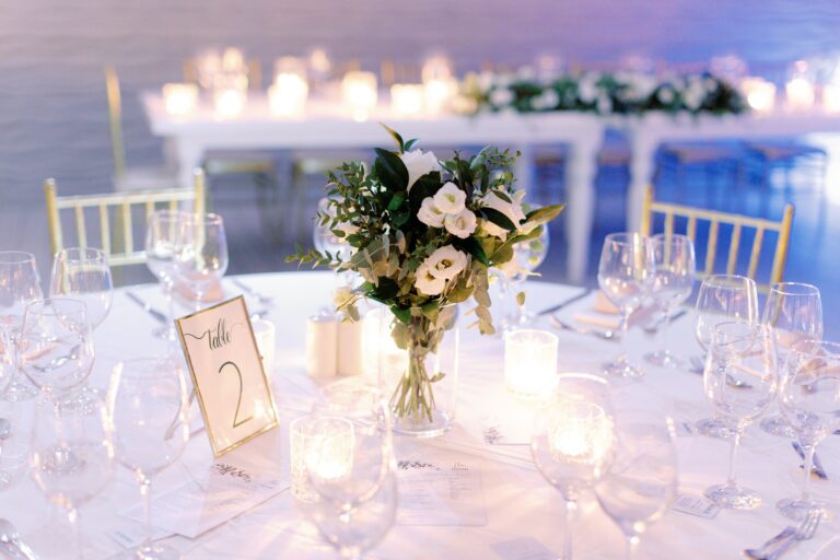 Candlelit top table with a table number and flowers, Galu Seaside