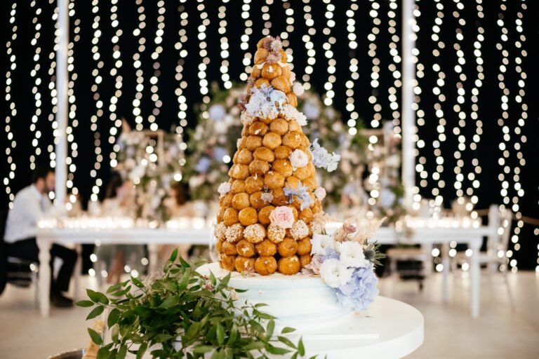 Croquembouche on the dessert table against a curtain of lights, Galu Seaside