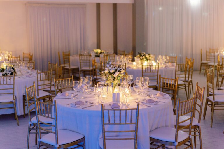 Round tables laid for an indoor wedding dinner, Galu Seaside