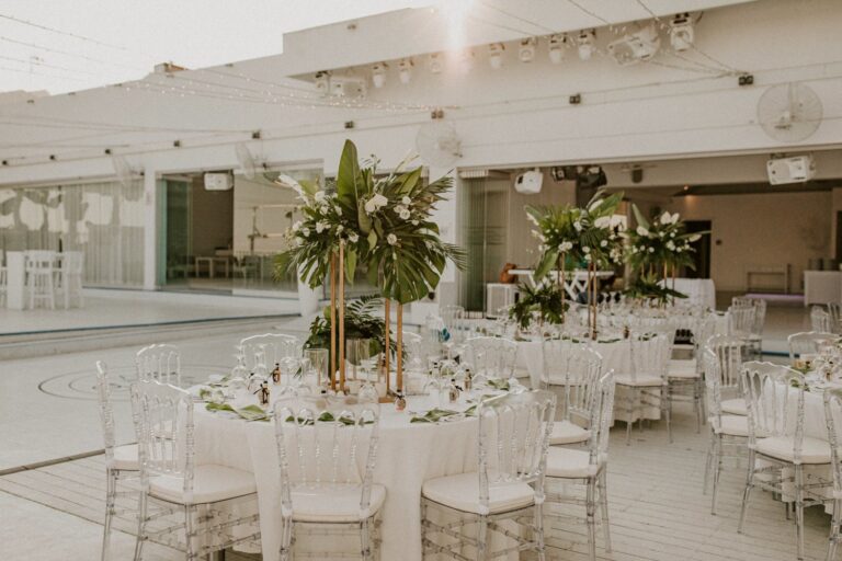 The indoor hall set with round tables and tall floral centrepieces, Galu Seaside