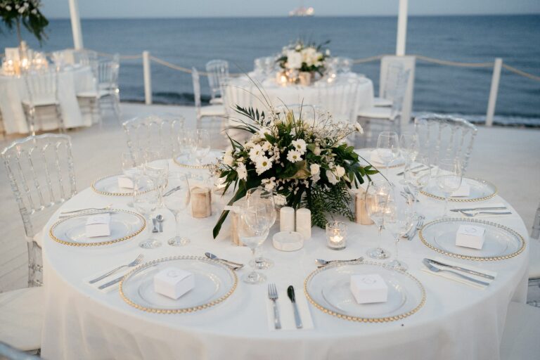 Round table with a floral centrepiece and the sea behind, Galu Seaside