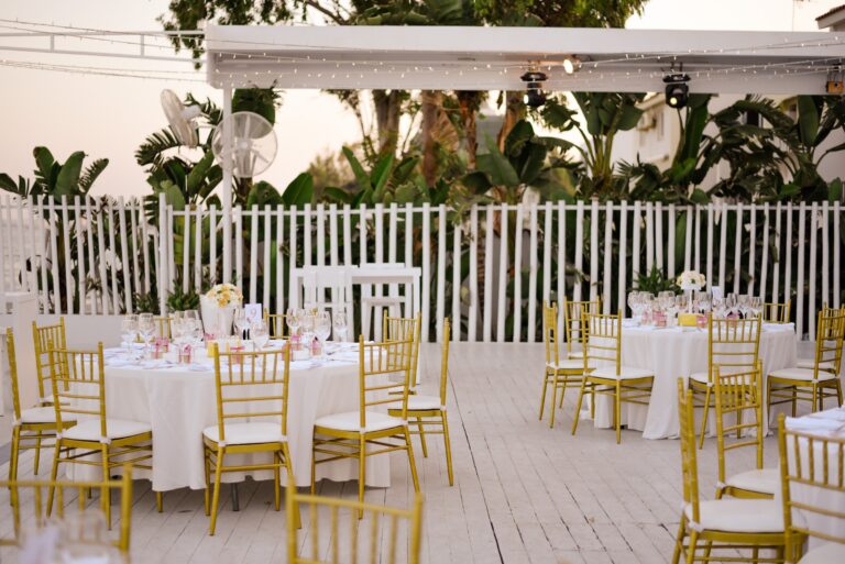 Terrace tables set for a reception beside the white fence, Galu Seaside