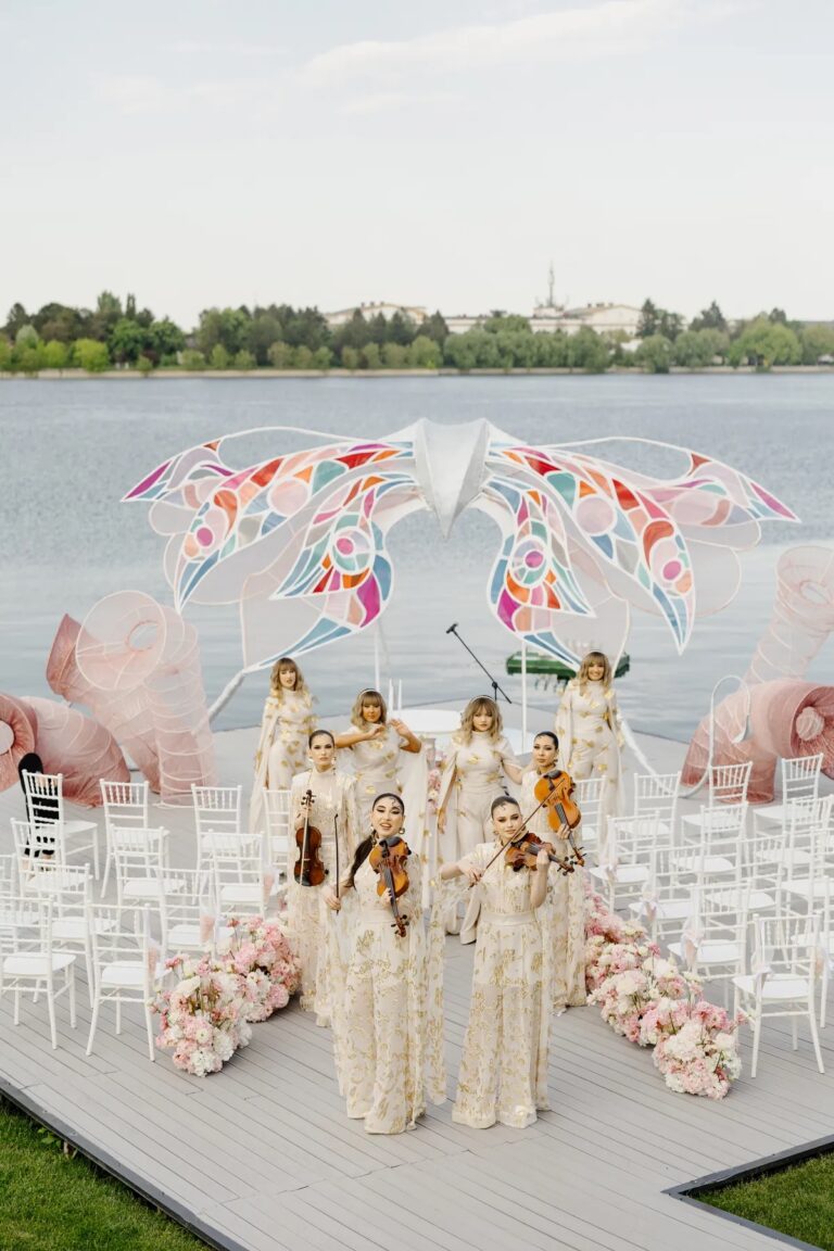 Lakeside ceremony platform with white chairs and a string ensemble, Geta Ungurean Agency
